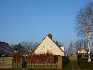 una casa blanca con una valla en un patio en Holiday Home Noordwijk near the Beach, en Noordwijkerhout
