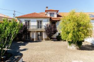 a large white house with a yard with trees at Feel Discovery Casa Da Capela Douro Valley in Armamar