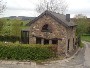 a stone house with an arched window on a street at Romantic holiday house in the Ardennes in Nadrin