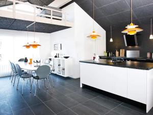 a kitchen with white cabinets and a table and chairs at 10 person holiday home in Brovst-By Traum in Brovst