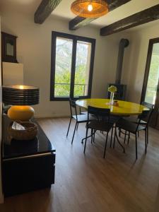 a dining room with a yellow table and chairs at Villa fleurie - maison familiale, véranda et jardin in Tende +26 photos