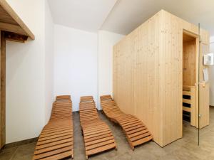 three wooden chairs in a room with a wall at Chalet in Alpendorf near Ski Slopes in Alpendorf
