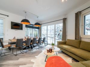 a living room with a table and a dining room at Chalet in Alpendorf near Ski Slopes in Alpendorf +17 photos