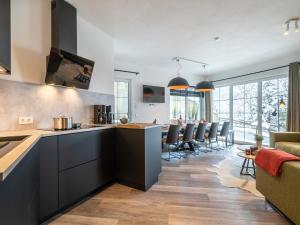 a kitchen with black cabinets and a living room at Chalet in Alpendorf near Ski Slopes in Alpendorf