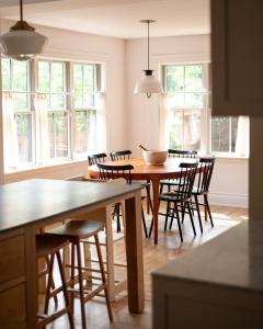 a kitchen with a table and chairs and windows at Sun-Filled Century Home in Hamilton +19 photos