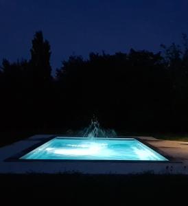 a pool of water in the dark at night at La Ferme Aux Arts in Beaumont-sur-Grosne