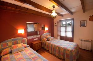 una camera da letto con due letti e una finestra di Apartamentos el Cueto de los Collado a Villanueva de Pría