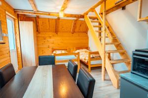 a dining room with a table and chairs and a staircase at STD Stara Vodenica in Crni Vrh