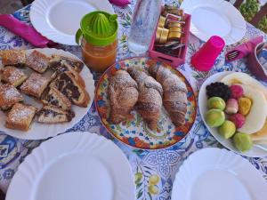 a table with plates of pastries and fruit on it at La Casa sulla Collina in Altavilla Silentina