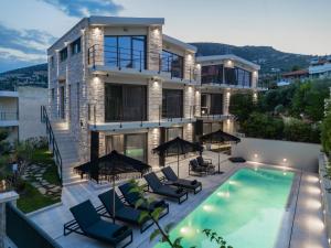 a house with a swimming pool in front of it at Petra Suites Tolo in Tolo