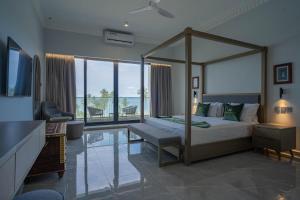 a bedroom with a canopy bed and a living room at Tembo Kiwengwa Resort in Kiwengwa
