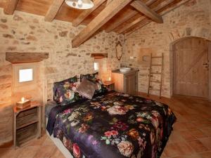 una camera con un letto in una stanza con pareti in pietra di Dreamy Retreat in Loubejac a Loubejac