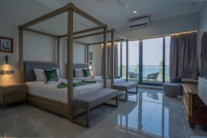 a bedroom with a canopy bed and a living room at Tembo Kiwengwa Resort in Kiwengwa