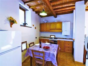 cocina con mesa y mantel púrpura en Charming Stone Retreat, en Castiglion Fiorentino