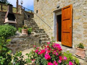 Un antiguo edificio de piedra con una puerta de madera y flores. en Charming Stone Retreat, en Castiglion Fiorentino 30 fotos más