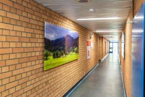 a painting hanging on a brick wall with a hallway at Euro Inn - Hotel in Lahr +9 photos