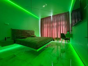 a green bedroom with a bed and a chair at ЖК Елегія парк in Odesa