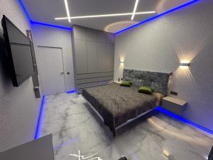 a bedroom with a bed with blue lights on it at Елегія парк in Odesa