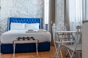 a bedroom with a blue bed and two chairs at Celtic Lodge - Guest House in Viseu