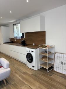 a kitchen with a washing machine in a room at Rez de villa Grand T2 in Sarrola-Carcopino