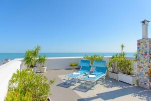 a patio with blue chairs and the beach at Hotel Nobel in Gabicce Mare