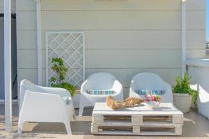 two white chairs and a table on a patio at Hotel Nobel in Gabicce Mare