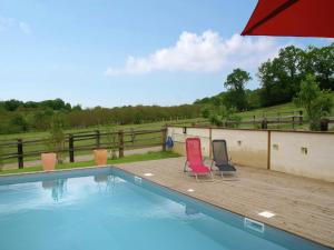 two chairs sitting on a deck next to a swimming pool at Nature Escape in Loubressac in Loubressac