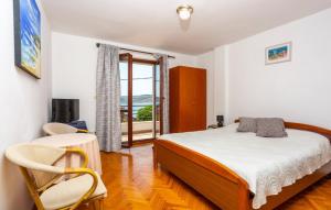 ein Schlafzimmer mit einem Bett und zwei Stühlen und einem Fenster in der Unterkunft Holiday home Villa Blue coast by Villas Guide in Jadranovo