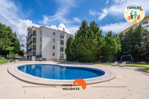 a swimming pool in front of a building at #230 Only Families - Flat A Flor by Home Holidays in Albufeira
