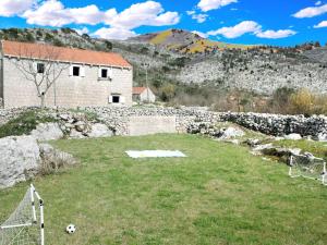 Un campo con un balón de fútbol y un muro de piedra en Stone House in Brotnice near Cavtat & Sea, en Cavtat