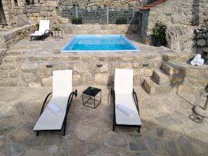 Un patio con dos sillas y una piscina. en Stone House in Brotnice near Cavtat & Sea, en Cavtat