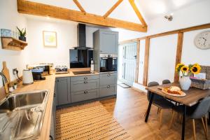 a kitchen with a wooden table and a counter top at Eleri's Barn in Rhayader