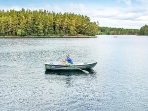 a man is rowing a boat on a lake at 6 person holiday home in Vena in Vena +8 photos