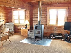 een woonkamer met een houtkachel in een hut bij Rustic Retreat with View - By Traum Ferienwohnungen in Søndervig