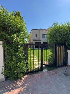 a black gate with bushes in front of a house at Marassi سيدى عبدالرحمان in El Alamein