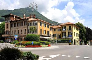 eine Straße in einer Stadt mit Gebäuden und einem Berg in der Unterkunft Trattoria Laghee con alloggio in Cernobbio