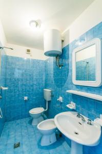 uma casa de banho azul com 2 WC e um lavatório em Residence Sabrina em Bibione