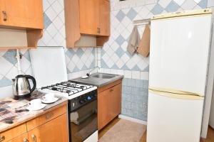 a kitchen with a stove and a sink and a refrigerator at 1-к квартира, Харківська, 38 in Sumy