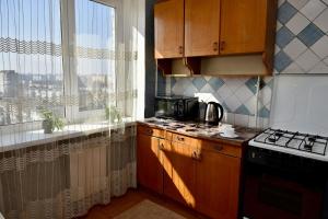 a kitchen with a stove top oven next to a window at 1-к квартира, Харківська, 38 in Sumy