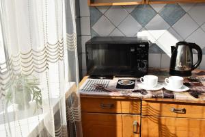 a kitchen with a microwave and two cups on a counter at 1-к квартира, Харківська, 38 in Sumy