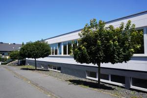 a building with two trees next to a street at Renatus Apartments in Eschau