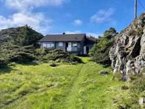 een huis op een heuvel met een groen veld bij 6 person holiday home in Espevær-By Traum in Espevær