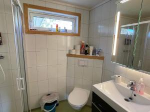 a bathroom with a toilet and a sink and a window at 4 star holiday home in Espevær in Espevær