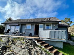 een klein blauw huis met een veranda en een trap bij 6 person holiday home in Espevær-By Traum in Espevær