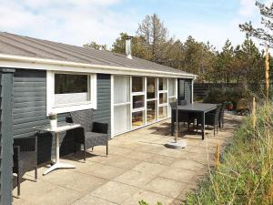 un patio con tavolo, sedie e una casa di Bright Coastal Retreat in Vorupor-By Traum a Thisted Altre 24 foto
