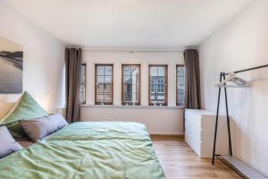 Un dormitorio con una cama, un escritorio y ventanas. en Werner-Senger-Haus Limburg, en Limburg an der Lahn