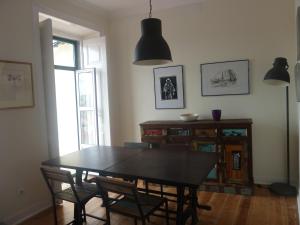 a dining room with a black table and chairs at Casa do Beco in Lisbon