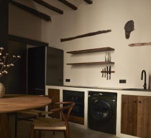 a kitchen with a washing machine and a dining room table at Enoa Casa Cueva - Alojamiento rural in Requena +21 photos