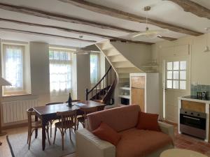 a living room with a couch and a table at Le Corps de Garde du château in Saint-Martin-des-Champs