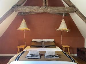 a bedroom with a bed with two hanging baskets at Le Corps de Garde du château in Saint-Martin-des-Champs